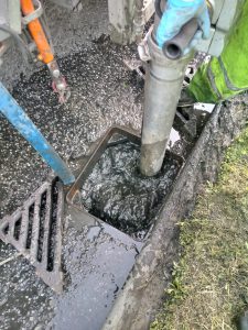 Workers using a machine to unblock a gully on the A180