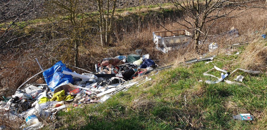 Waste fly-tipped next to a ditch by the A180 in Grimsby.