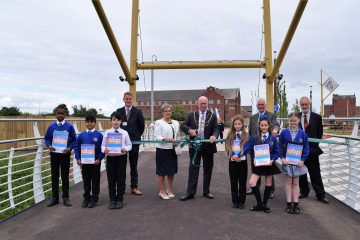 A photo of the bridge ribbon cutting ceremony taking place.