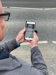 A man holding a phone to illustrate the FitRoutes app