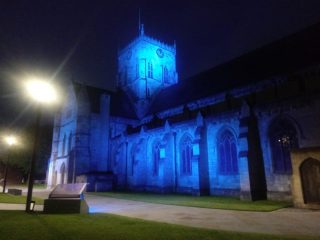 A photo of Grimsby Minster lit up blue
