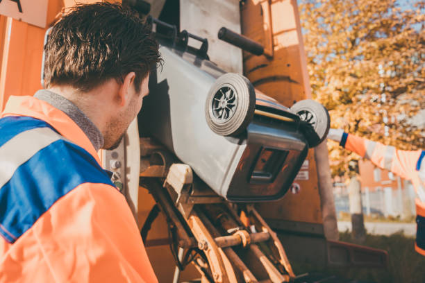 Worker emptying bin into waste vehicle