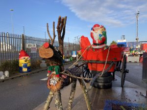 Log reindeer pulling a cart with a plastic Santa.