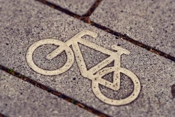 A bike path sign on the ground
