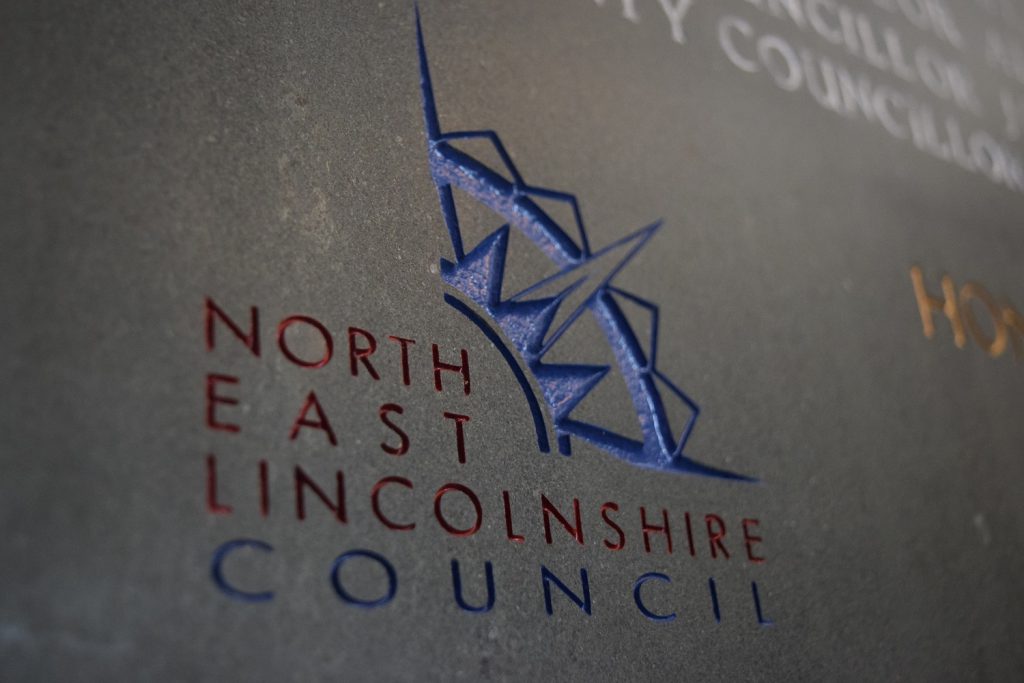 NELC logo in stone