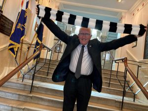 Mayor of North East Lincolnshire Council, Cllr Stephen Beasant, waves a Grimsby Town scarf.