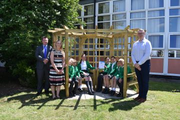 Modeshift STARS staff and pupils at Pilgrim Academy sitting and standing outside on the grass.