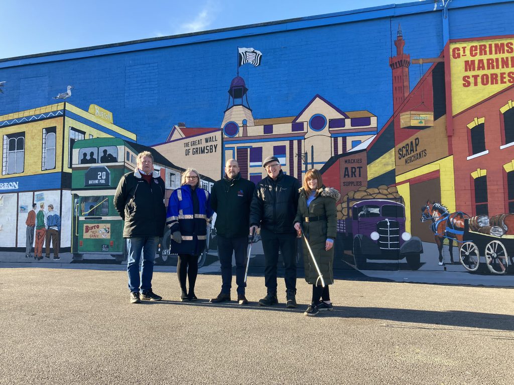 Councillors and officers in front of the Great Wall of Grimsby.