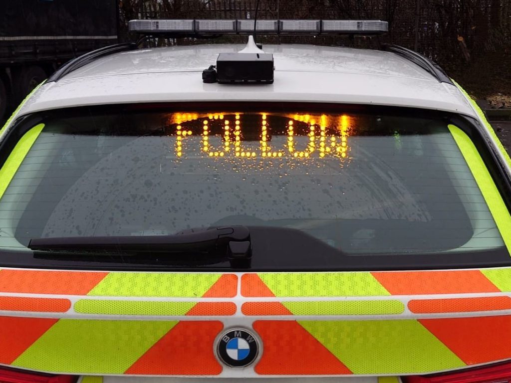 Police car with illuminated follow signal