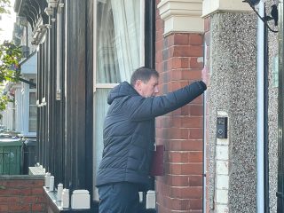 A photo of an officer knocking on a door