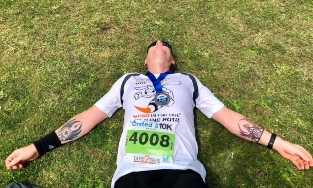 Scott laying down on the grass after running the Grimsby 10k