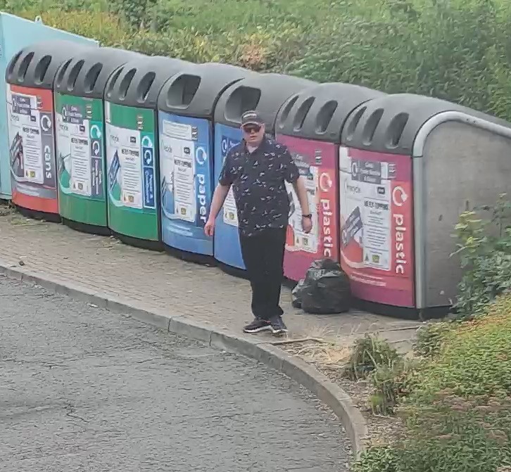 A person next to a bring to recycling site.