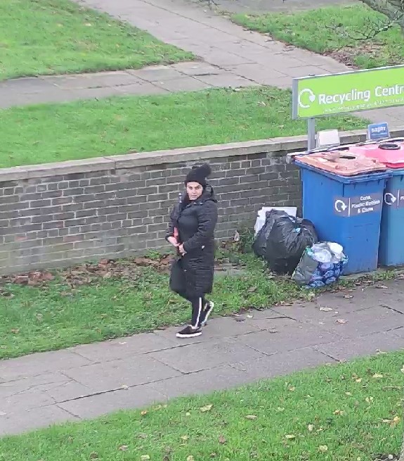 A person walking away from some bins