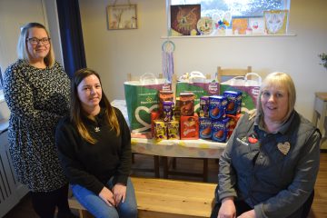 A photo of children's services staff accepting a gift of Easter eggs for children in case, from Morrisons Community Champion, Theresa.