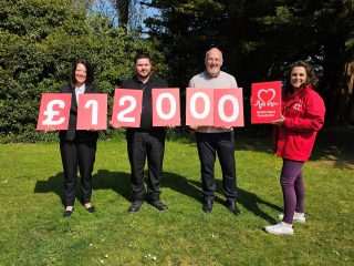 The photo shows Lisa Crookes and Daniel Intress-Franklin from North East Lincolnshire Council with Tony Lightfoot and Melanie Meik from British Heart Foundation. They are holding up cards with figures spelling twelve thousand pounds.