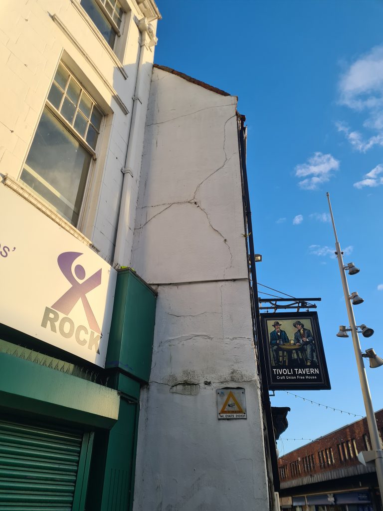 Cracked and flaking render on a Grimsby pub