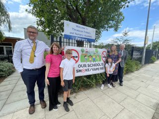 A photo of staff and students posing in front of a banner