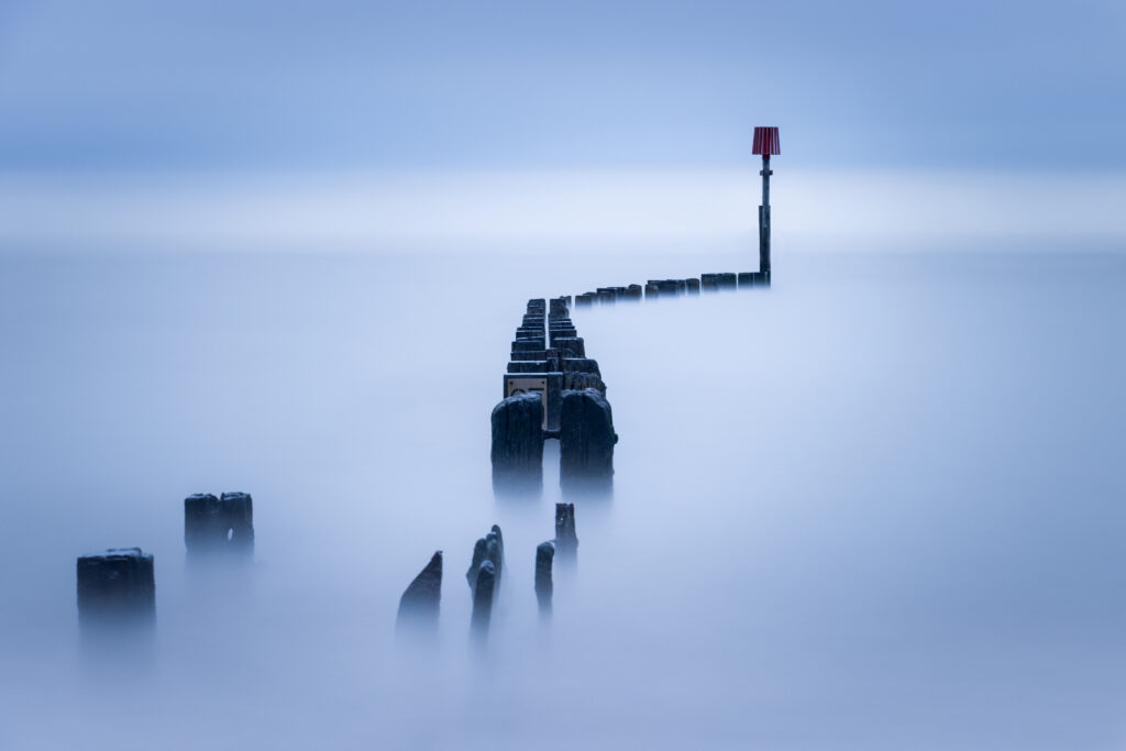 Atmospheric shot of the posts in the water at the beach