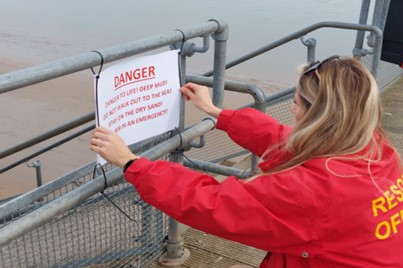 Woman putting a 'danger' sign up