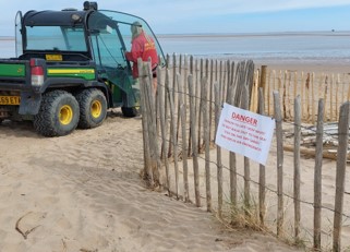 'Danger' sign and beach safety vehicle on the beach