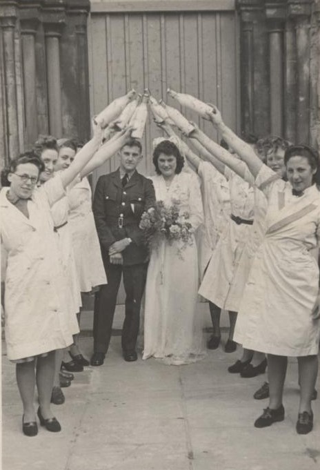 Bride and groom under a guard of honour, using milk bottles as swords
