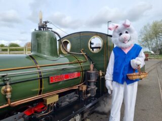 A person dressed as the Easter bunny stood in front of a train at Cleethorpes Coast Light Railway