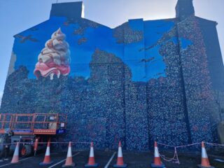 Mural being painted on the wall of a building