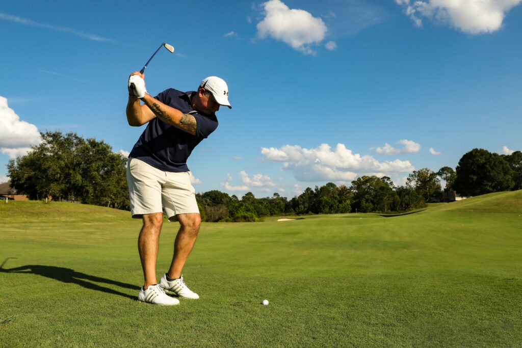 Man hitting a golf ball on a field