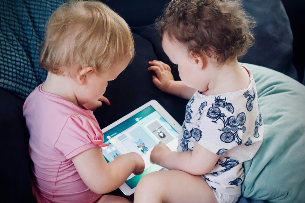 Two babies looking at a digital tablet