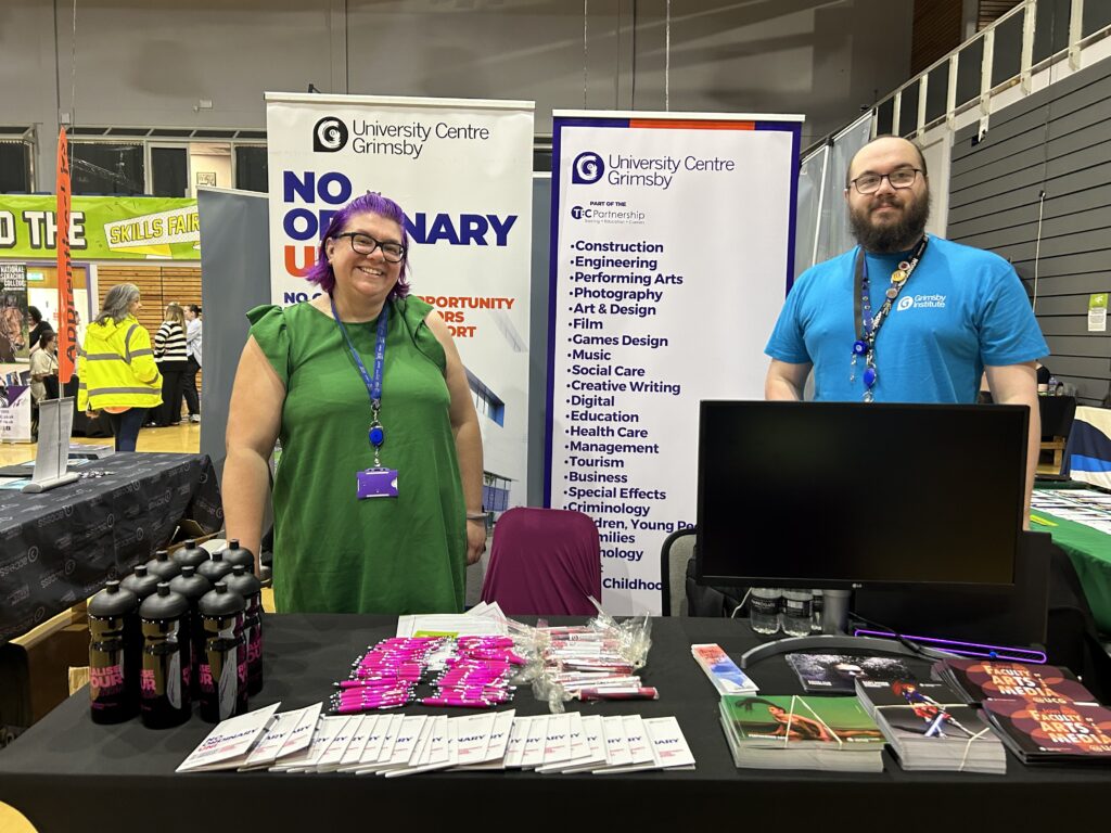 Man and woman stood at a stall at a careers event