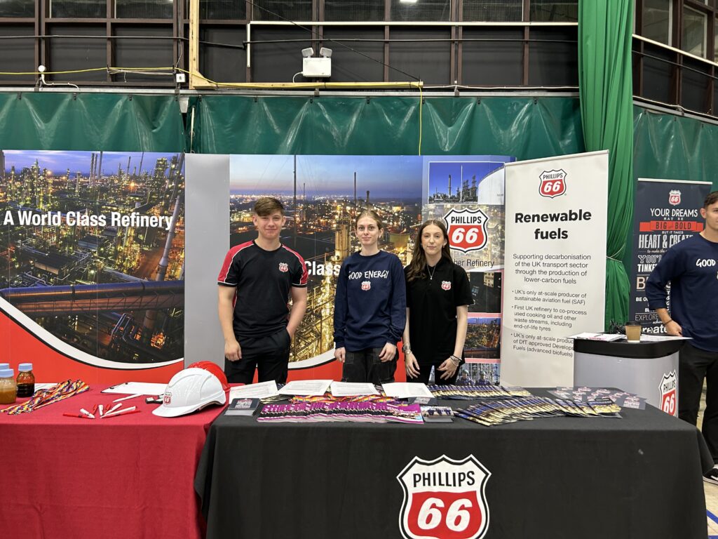 Man and two women stood at a stall at a careers event