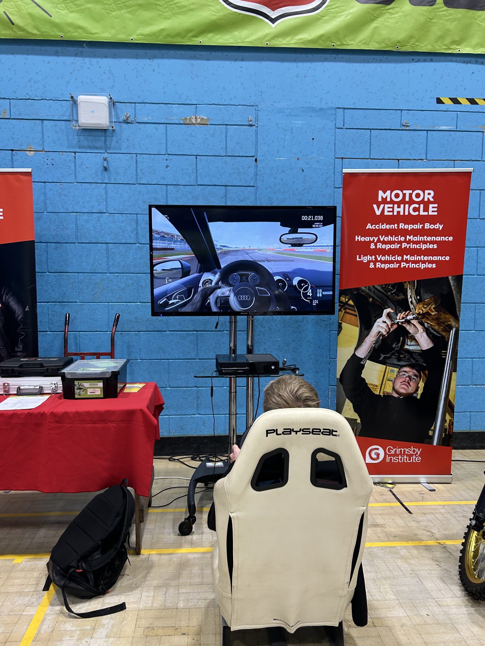 Young adult playing on a racing simulator at a careers fair