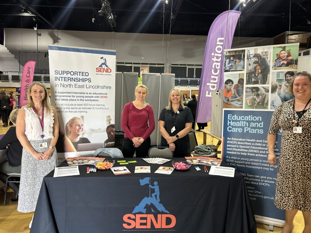 Four women stood at a stall at a careers event