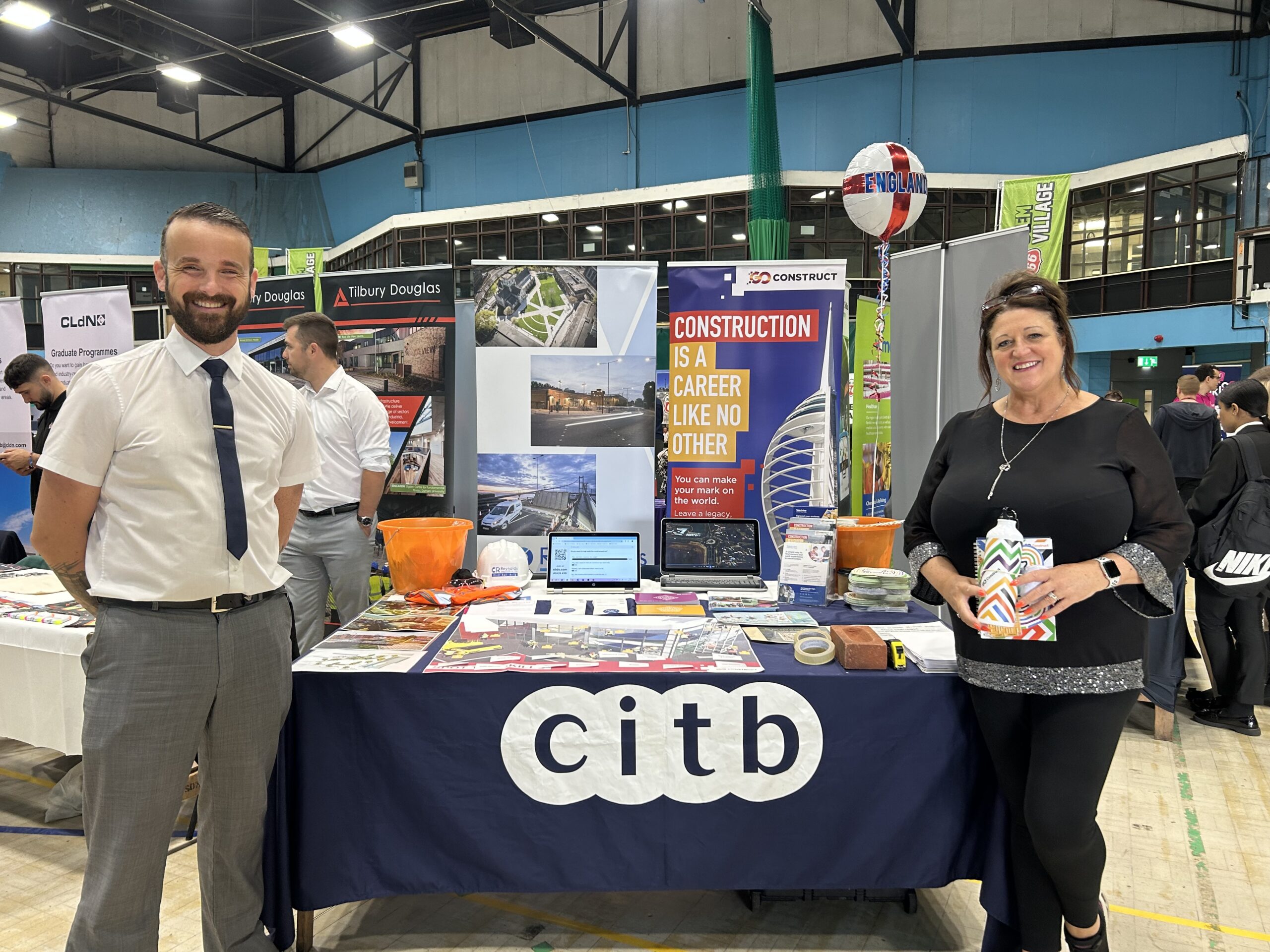 Man and woman stood at a stall at a careers event