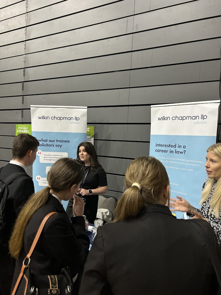 Students talking to two women at a careers fair