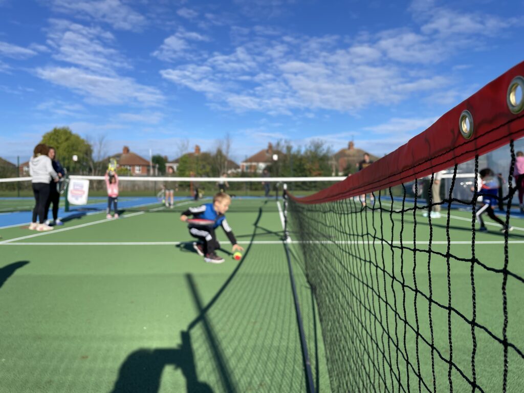 Children playing tennis at the opening day of the courts