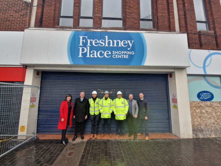 Several people in front of a Freshney Place sign
