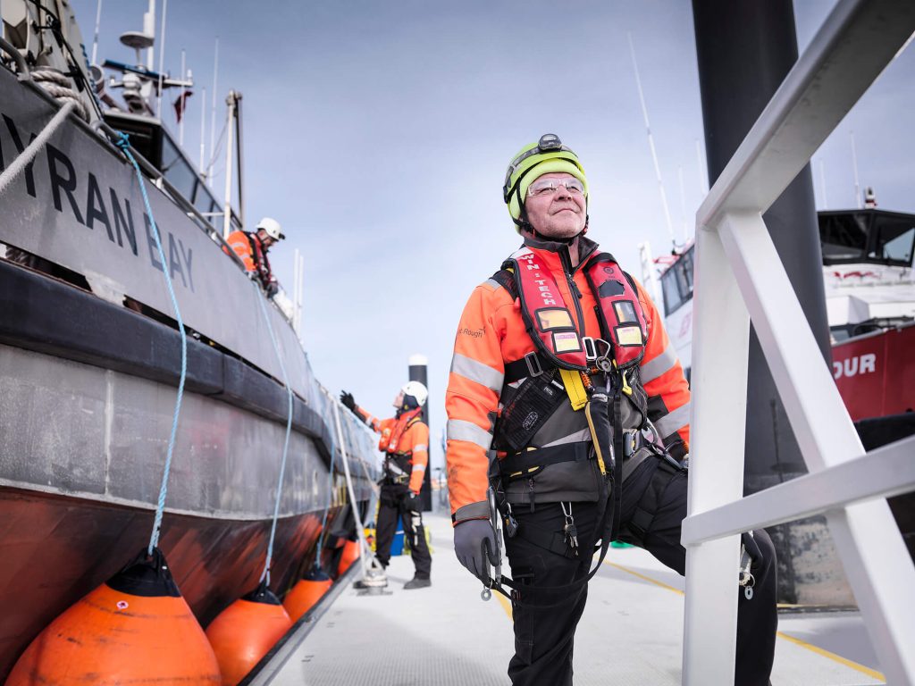 Man in workwear stood on a boat