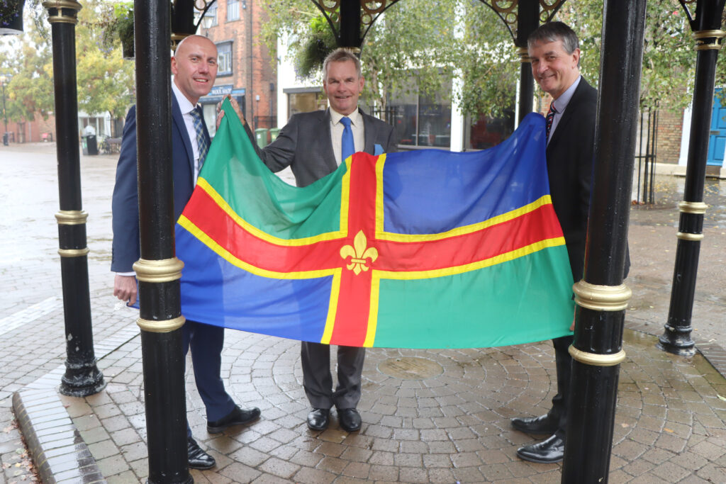Lincolnshire leaders together with a Greater Lincolnshire flag following a successful devolution deal