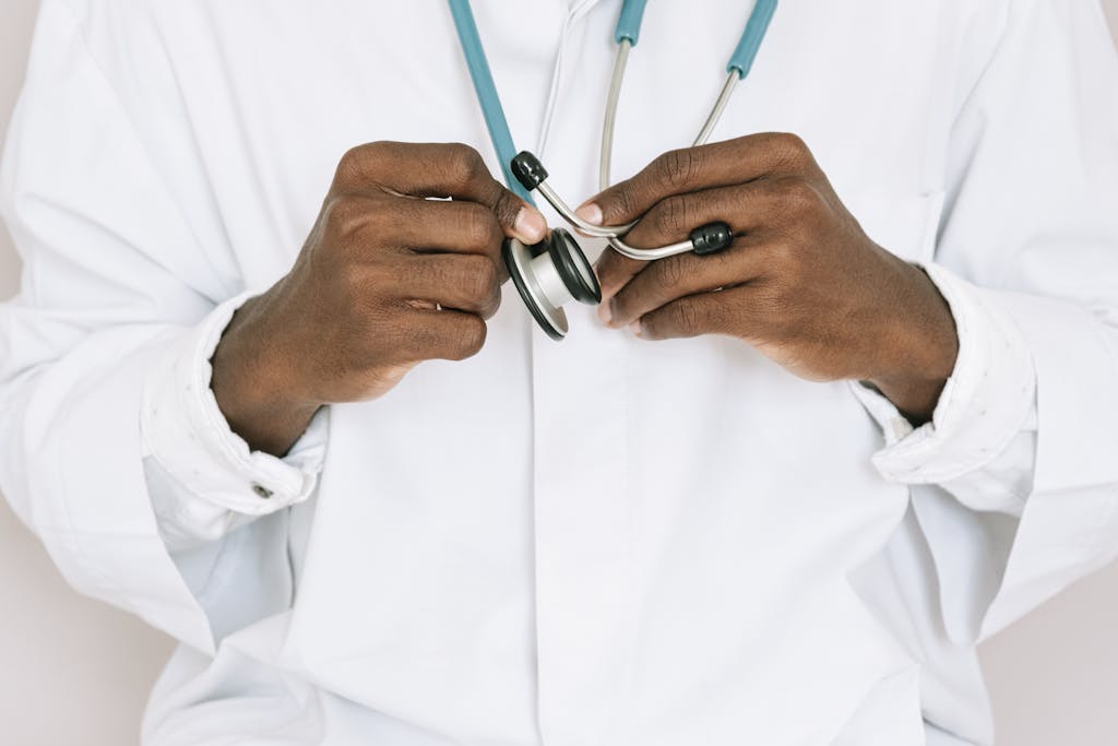 A professional doctor holding a stethoscope, focusing on hands and medical tools.