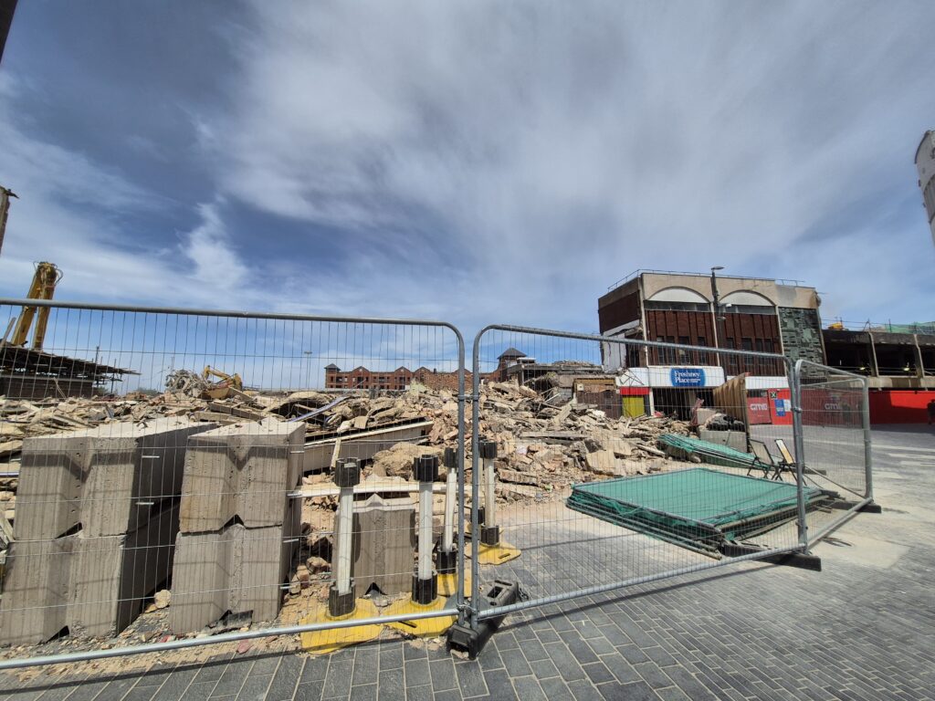 Rubble behind heras fence