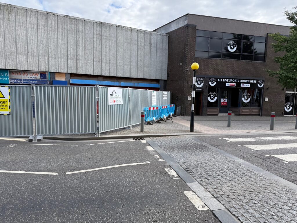 Buildings with hoarding around them