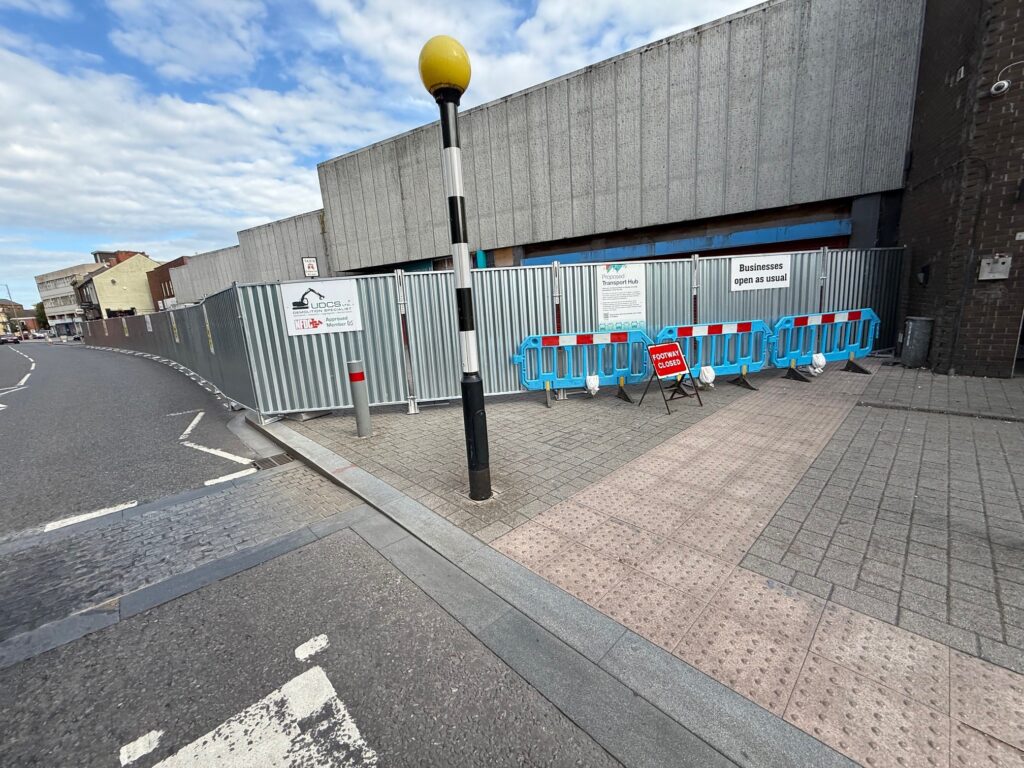 Buildings with hoarding around them