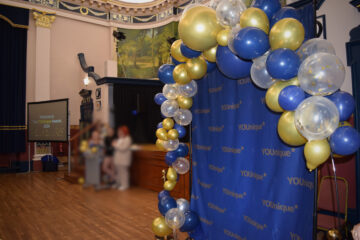 A blue and gold balloon arch with a photo backdrop in the town hall Grimsby