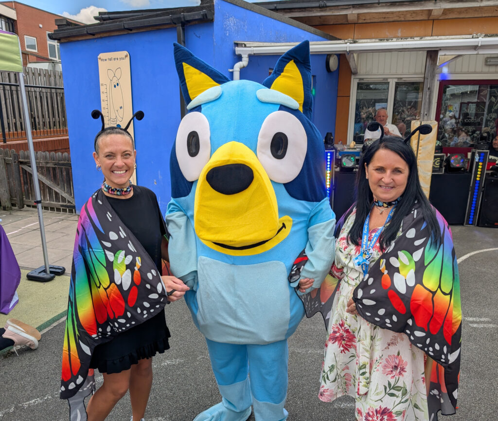 Bluey and 2 members of staff dressed up as butterflies at the Central Family Hub smiling