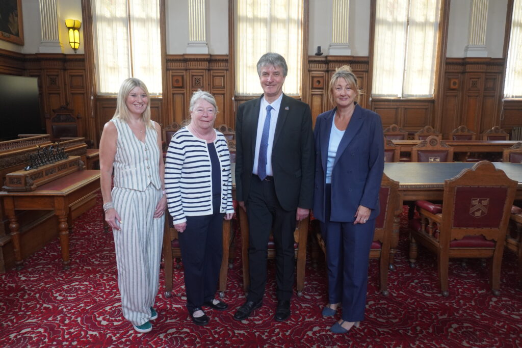 A photo of four people in a room