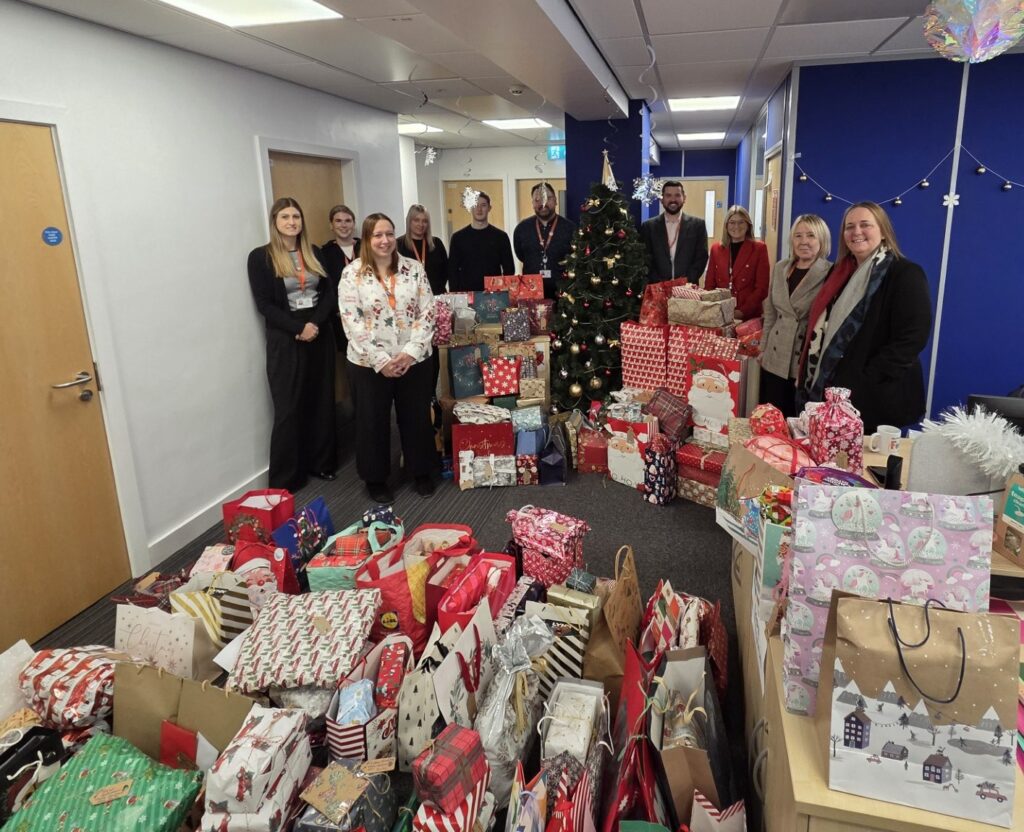 A pile of presents in front of the CAPE team and leaders at North East Lincolnshire Council