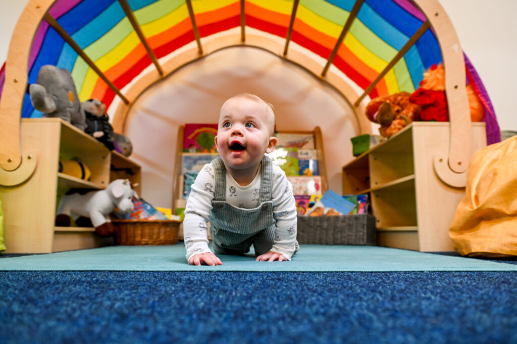 baby crawling under rainbow