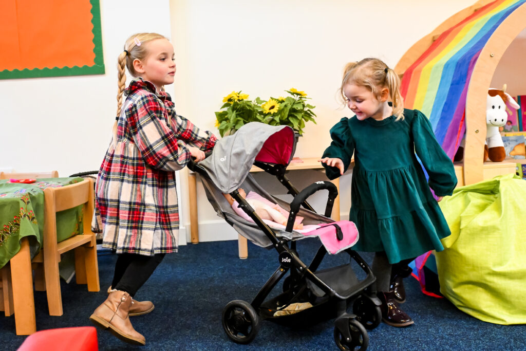 two young girls pushing a pram
