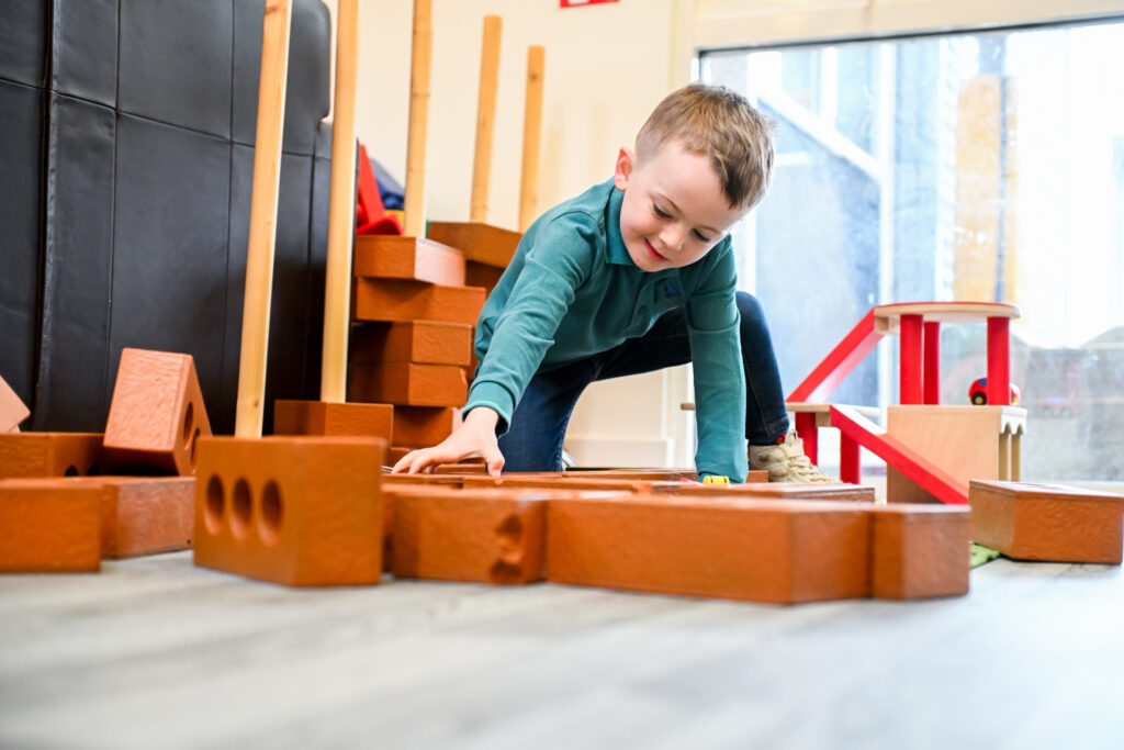 a young boy playing with bricks